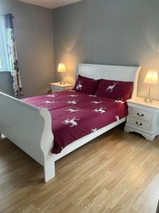 a bedroom with a bed with a purple comforter at Meelin cottage in Cork