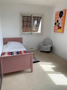 1 dormitorio con cama, ventana y silla en Appartement CANNES, vue mer triples exposition en Cannes