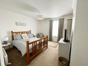a bedroom with a bed and a television in it at Coastal Terrace Dogs Welcome optional Hot Tub in Sea Palling