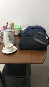 a bag sitting on a table with a cup of coffee at Citisquare apartment for good sleeper in Tenggilismedjojo