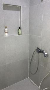 a shower with a shower head in a bathroom at Citisquare apartment for good sleeper in Tenggilismedjojo