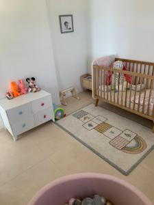 um quarto para bebés com um berço e uma cómoda em Appartement CANNES, vue mer triples exposition em Cannes