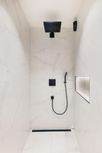 a bathroom with a shower with white marble walls at Bryggen Living in Bergen