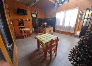 a room with a table and a kitchen with a christmas tree at HOSTAL PLAYA ANCHA in Valparaíso