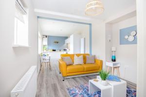 een woonkamer met een gele bank en een tafel bij Apartment One - King Bed - Free Private Parking - by Ocean City Retreats in Plymouth