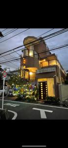 un edificio con flores al lado de una calle en 東洋の家-畳み部屋小庭園, en Tokio