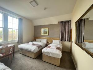 a hotel room with two beds and a mirror at Earl David Hotel in East Wemyss