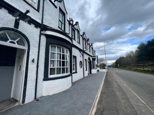 a white building on the side of a street at Earl David Hotel in East Wemyss