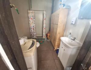 a bathroom with a toilet and a sink and a shower at HOSTAL PLAYA ANCHA in Valparaíso