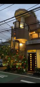 un edificio con árboles de Navidad delante de un edificio en 東洋の家-畳み部屋小庭園, en Tokio