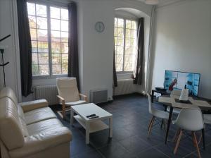 een woonkamer met een bank en een tafel bij O'Couvent - Appartement 87m2 - 4 chambres - A511 in Salins-les-Bains