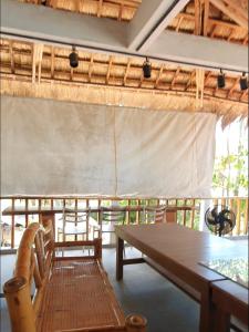 uma sala de jantar com uma mesa de madeira e cadeiras em Mabuhay Dauin Dorm Hostel em Dauin