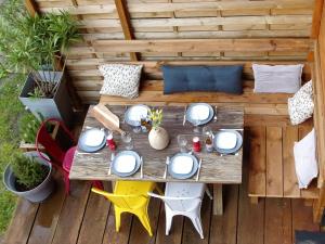 una terraza con vistas panorámicas a una mesa de madera y sillas. en La petite gravière Océane, en Messanges