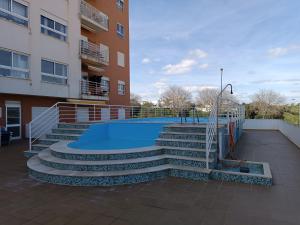 a building with a swimming pool and stairs next to a building at Casa dos Avós - Quinas II in Armação de Pêra