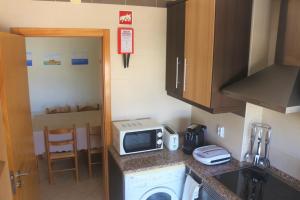 a kitchen with a washer and a microwave on a counter at Casa dos Avós - Quinas II in Armação de Pêra