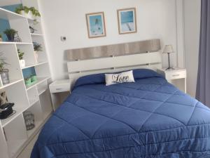 1 cama con edredón azul en un dormitorio en Apartamento Costa del Sol en Mar del Plata