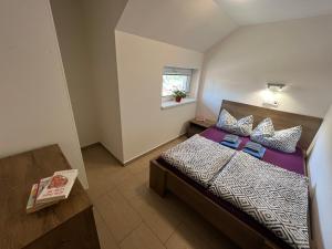 a small bedroom with a bed and a window at Rodinný penzion MARMAR in Staré Město