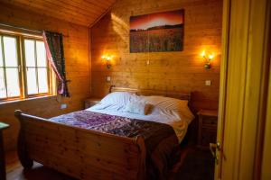 - une chambre avec un lit dans une cabane en bois dans l'établissement George Cabin - Log Cabin in Wales with Hot tub, à Newtown
