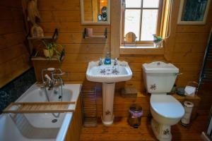 La salle de bains est pourvue d'un lavabo, de toilettes et d'une baignoire. dans l'établissement George Cabin - Log Cabin in Wales with Hot tub, à Newtown