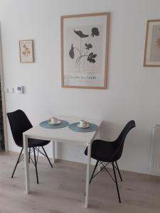 a white table and two chairs in a room at Sunny Home Veszprém in Veszprém