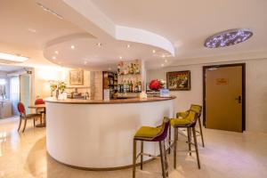 a bar in a room with stools at Hôtel Les Trois Roses, Meylan Grenoble in Meylan