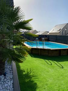 uma piscina num quintal com um relvado verde em Loue maison très proche du circuit des 24h du Mans em Mulsanne