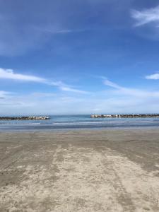 una playa con el océano y casas en el fondo en La mimosa, en San Mauro Pascoli