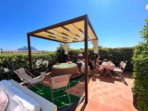 a patio with a gazebo and a table and chairs at Relais del Borgo- Domo in Porto San Paolo