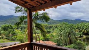 a view from the porch of a resort with a palm tree at Chalé Recanto da Cachoeira I in Eldorado