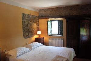 a bedroom with a white bed and a window at Agriturismo Cilla in Giuncugnano
