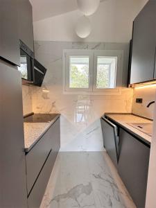 una cucina con ripiani in marmo e due finestre di Villa Wanda a Bibione Altre 21 foto