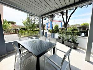 a black table and chairs on a patio with a view at Villa Wanda in Bibione
