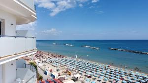 uma vista para uma praia com guarda-sóis e para o oceano em Hotel Mexico em Bellaria-Igea Marina