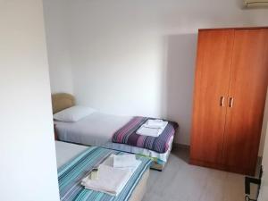 a small bedroom with a bed and a cabinet at Apartmani Čupić in Budva