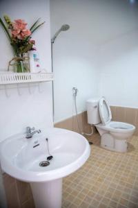 La salle de bains est pourvue d'un lavabo blanc et de toilettes. dans l'établissement Sichon Holidays, à Sichon