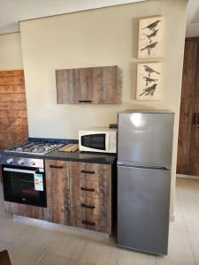 a kitchen with a refrigerator and a microwave at @Merino in Ermelo