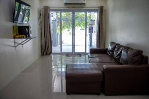 uma sala de estar com um sofá e uma porta de vidro deslizante em Sichon Holidays em Sichon