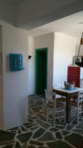 a dining room with a table and chairs and a green door at Anna's Cottage Home in Galini