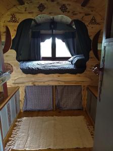 an inside view of a cabin with a window at Roulotte irlandaise Polly in Saint-Vincent-en-Bresse
