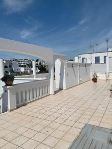 balcone con recinzione bianca e pavimento piastrellato di CASA LEUCA a Leuca