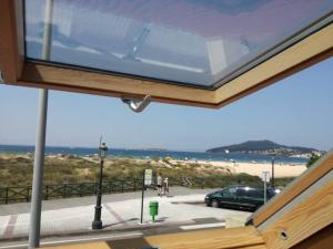 a view of the beach from the window of a house at una terraza al atlántico in Nigrán