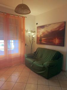un soggiorno con ottomana verde in una camera di CASA LEUCA a Leuca
