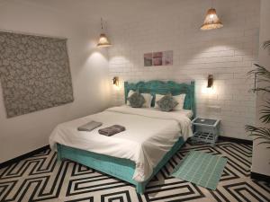 a bedroom with a bed with a green headboard at Hermitage Riviera in Arpora