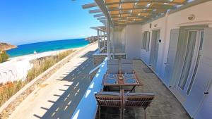 a patio with a table and chairs and the beach at 1Path Wave Mykonos Super Paradise Beach House in Mýkonos City