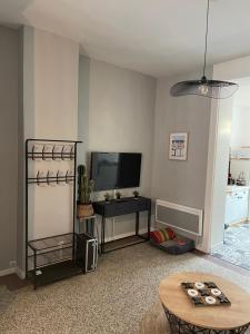 uma sala de estar com uma televisão e uma mesa em Grand’Heurt 50m de la plage em Le Portel