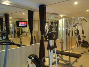 a gym with several tread machines and a television at Hotel Azimut in Sveti Stefan
