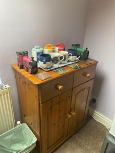 a wooden cabinet with many pots and pans on it at Tuebrook Towers in Liverpool