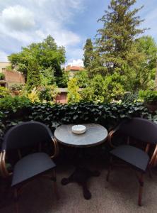 una mesa con 2 sillas y una mesa con un tazón en Flora Apartment, en Novi Sad