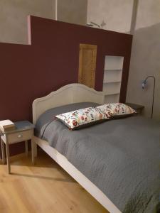 a bedroom with a bed with a wooden headboard at Les volets bleus in Charlieu