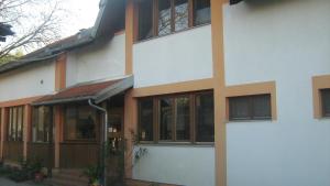 ein weißes Gebäude mit Fenstern und einer Tür in der Unterkunft Farm stay Lackovic in Bilje